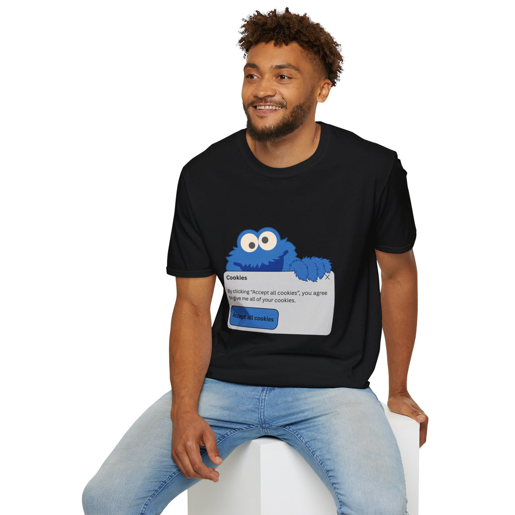 Man wearing a black t-shirt with a Cookie Monster graphic, sitting on a white stool against a white background.