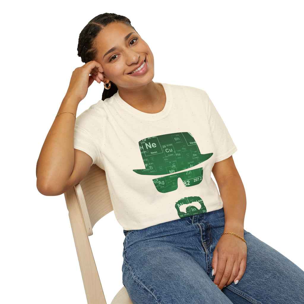 A person wearing a sand t-shirt with a green graphic, sitting on a chair.